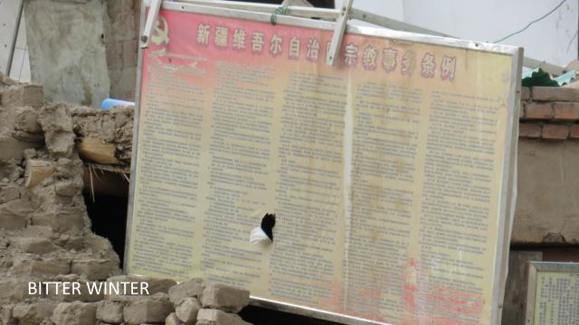 Resti di mura che ancora portano una bacheca con l’annuncio: «Norme per gli Affari Religiosi della regione autonoma uigura dello Xinjiang»