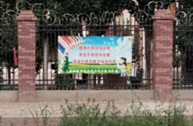 Slogan sulla recinzione: «Agli insegnanti è vietato avere un credo religioso, agli studenti è vietato avere un credo religioso». «Cancellate completamente le attività religiose dal campus».