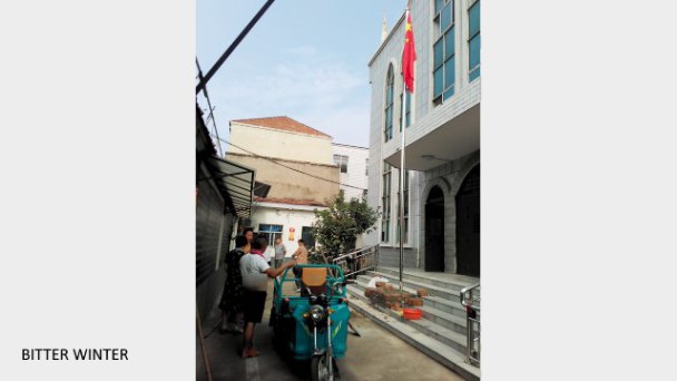 Una bandiera cinese viene issata in una chiesa del villaggio di Xiguan