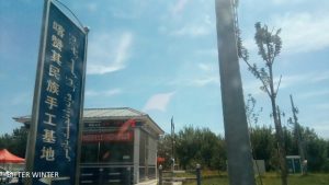 Segnaletica al centro per l’artigianato etnico nel sotto-distretto di Kazanqi, nello Xinjiang