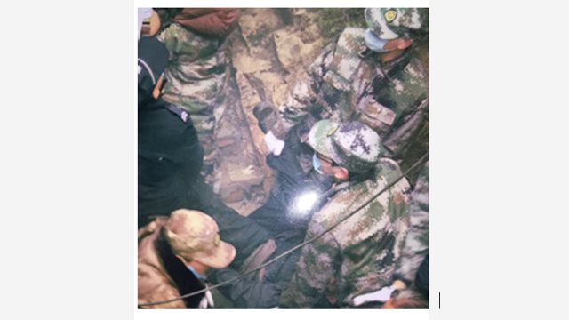 Agenti del PCC mentre trascinano giù dalla montagna, afferrandolo per le mani, un anziano abitante del villaggio che sorvegliava il tempio