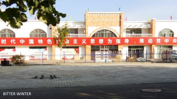 Slogan di propaganda del PCC esposti sul muro di cinta del campo per donne uigure