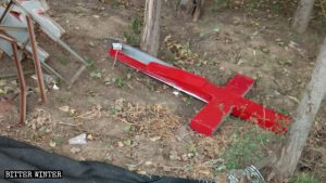 La croce della chiesa del villaggio smantellata e gettata a terra