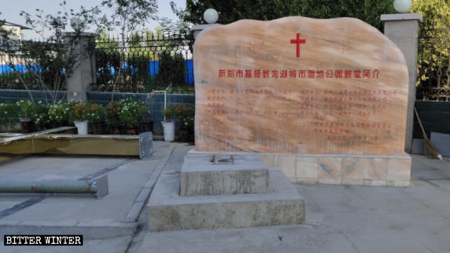 Una croce abbandonata accanto all'ingresso di una chiesa delle Tre Autonomie