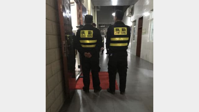Agenti ausiliari in servizio fanno la guardia all'ingresso della chiesa