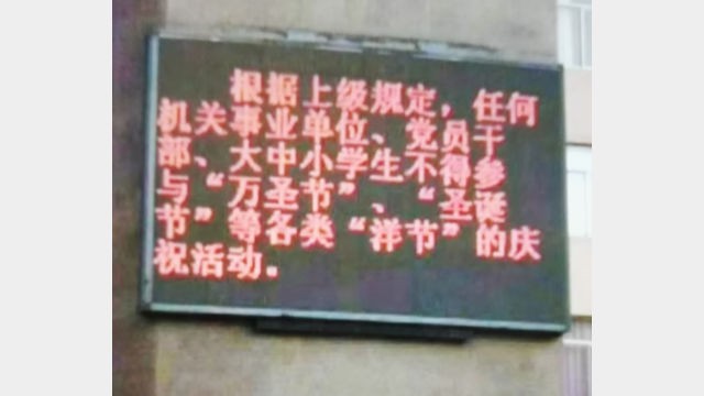 Un cartello a LED che vieta le celebrazioni natalizie all'ingresso di una scuola media nella città di Changle, nella provincia del Fujian (photo presa da WeChat)