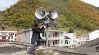 Un operaio installa alcuni altoparlanti