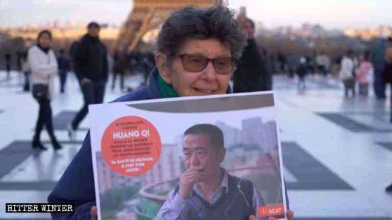 Una donna dell’ACAT con in mano una foto di Huang Qi