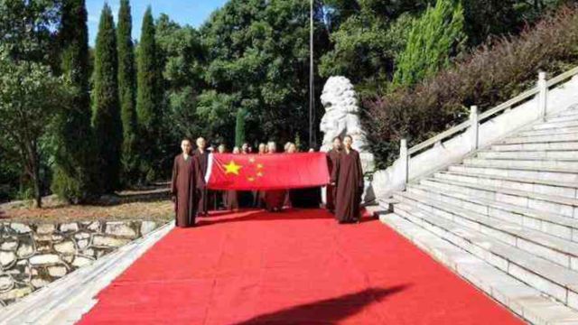 I monaci del tempio Wanshan nella città di Lushan, nello Jiangxi mentre partecipano alla cerimonia dell’alzabandiera