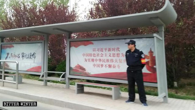 Un agente di sicurezza a una fermata dell'autobus a Qindao