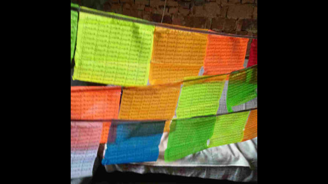 Una bandiera di preghiera con le scritture buddhiste sopravvissuta alla distruzione