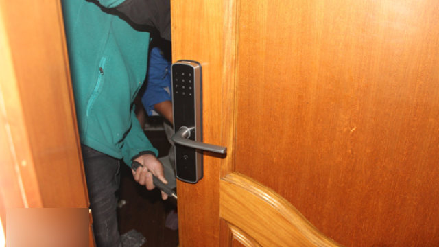 Un operaio sta installando una serratura intelligente in una proprietà in affitto