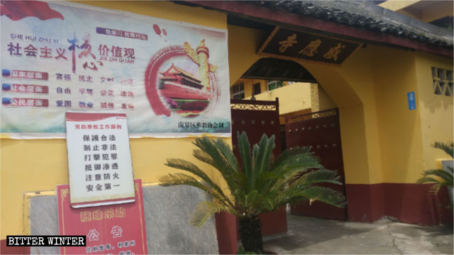 Un poster che riporta i valori centrali del socialismo è esposto all'ingresso di un tempio nella città di Hanzhong nello Shaanxi
