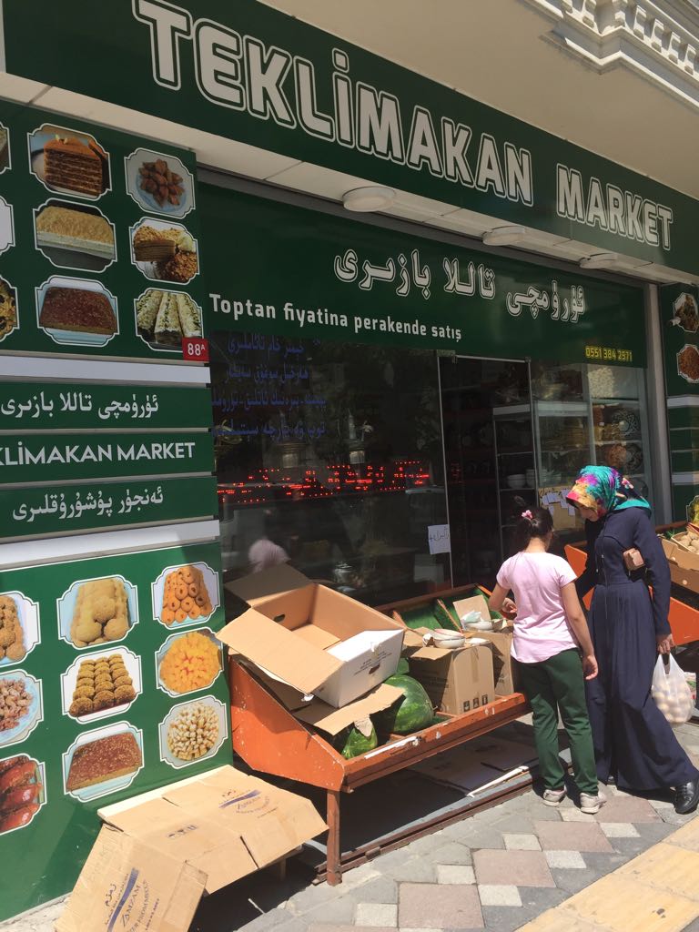 Un negozio uiguro a Zeytinburnu ha il nome dal deserto di Taklamakan nel sud dello Xinjiang, una vasta terra coperta di dune di sabbia in cui ci starebbe comodamente la Gran Bretagna. A partire dal cibo che viene pubblicizzato nella vetrina fino al contenuto e alla disposizione interna del negozio si può quasi sognare di essere a Urumqi, almeno finché, destandosi dal sogno ci si rende conto che non è così