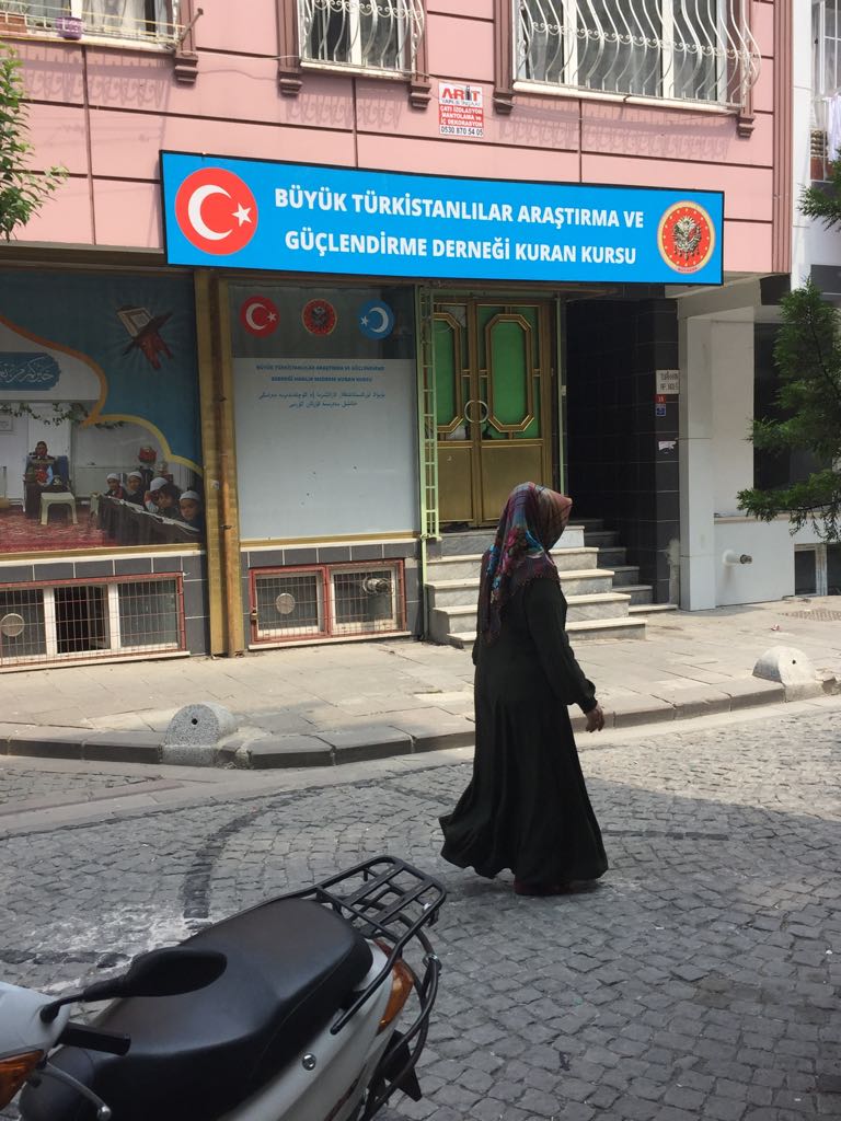 Una donna uigura passa davanti a una piccola madrassa (scuola di formazione islamica) per l'istruzione coranica nel distretto di Ziyghur a Zeytinburnu
