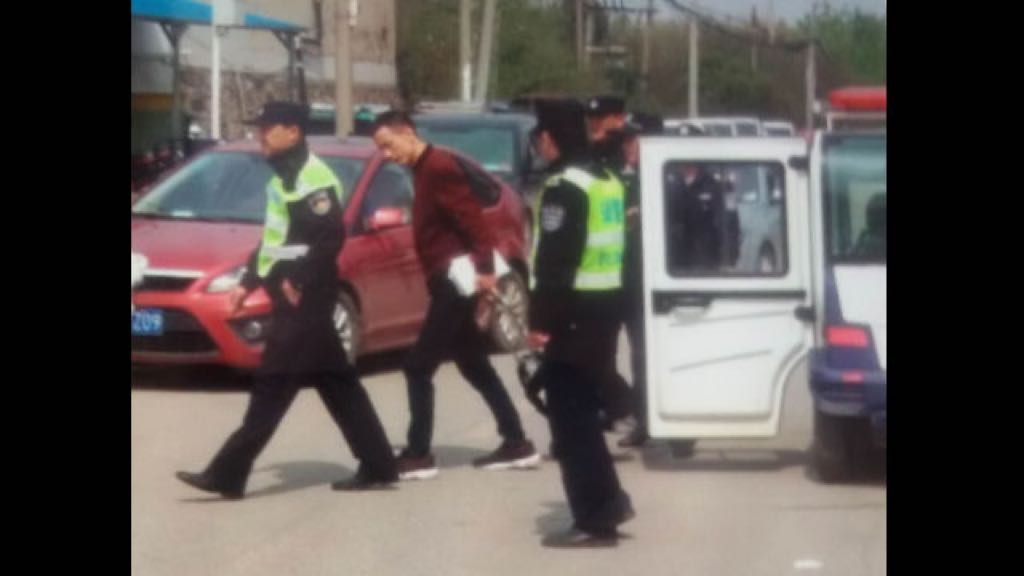 Un fedele della chiesa è stato portato via dalla polizia per aver distribuito volantini sul vangelo (foto WeChat)