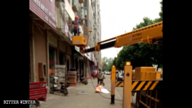 Gli agenti della gestione urbana rimuovono le insegne nel distretto Jiangxia di Wuhan