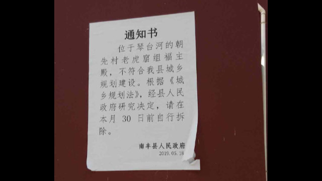 Una notifica di demolizione fissata al muro del tempio Fuzhu del villaggio di Chaoxian