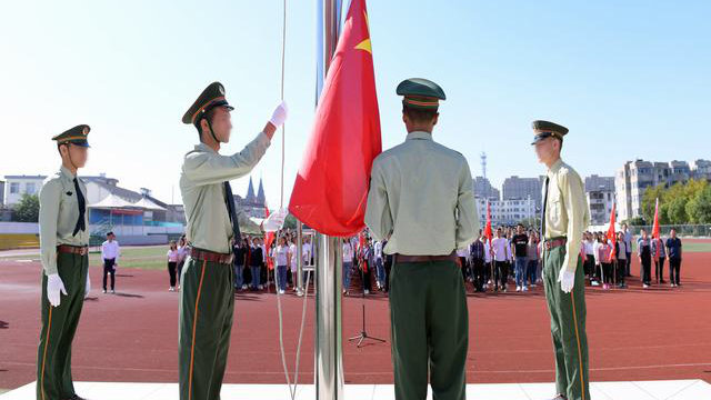 Alcuni studenti dello Xinjiang partecipano a una cerimonia di alzabandiera nella scuola superiore di Kou'an, nello Jiangsu