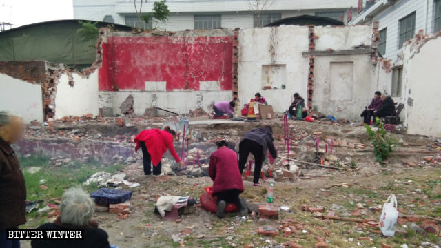 Anziani buddhisti pregano sulle rovine del tempio di Bodhi