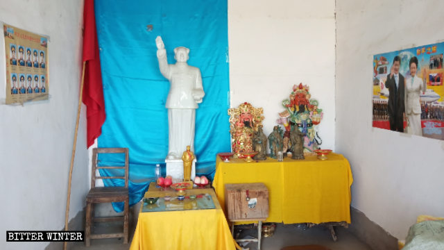 Una statua di Mao è esposta nella sala del tempio di Sanhuanggu e sul muro è affisso un poster con le immagini di Xi Jinping e di sua moglie