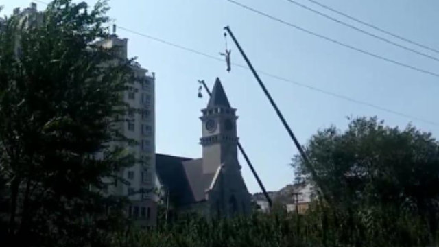 Una gru rimuove la statua di Gesù dal campanile della chiesa cattolica nel villaggio di Linjiazhuang
