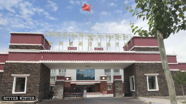 La bandiera cinese sventola sul cancello del Tibetan Buddhist College di Qinghai