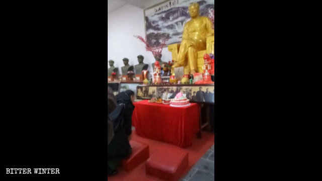 Persone inginocchiate davanti alla statua di Mao Zedong, a Shangrao, il 26 dicembre