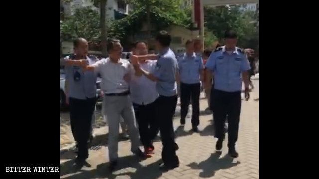 Poliziotti portano via un collaboratore della chiesa di Zhongxin