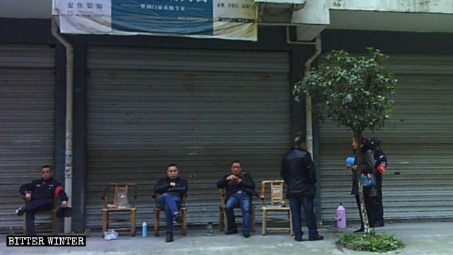 Personale dell'ufficio del sub-distretto sorveglia la chiesa di Qianxiang dall'altra parte della strada