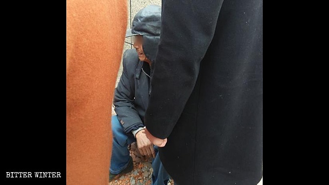 Un abitante del villaggio piange per la demolizione della sua casa
